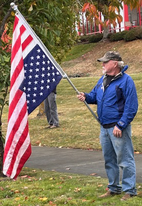 man carrying upside down U S flag